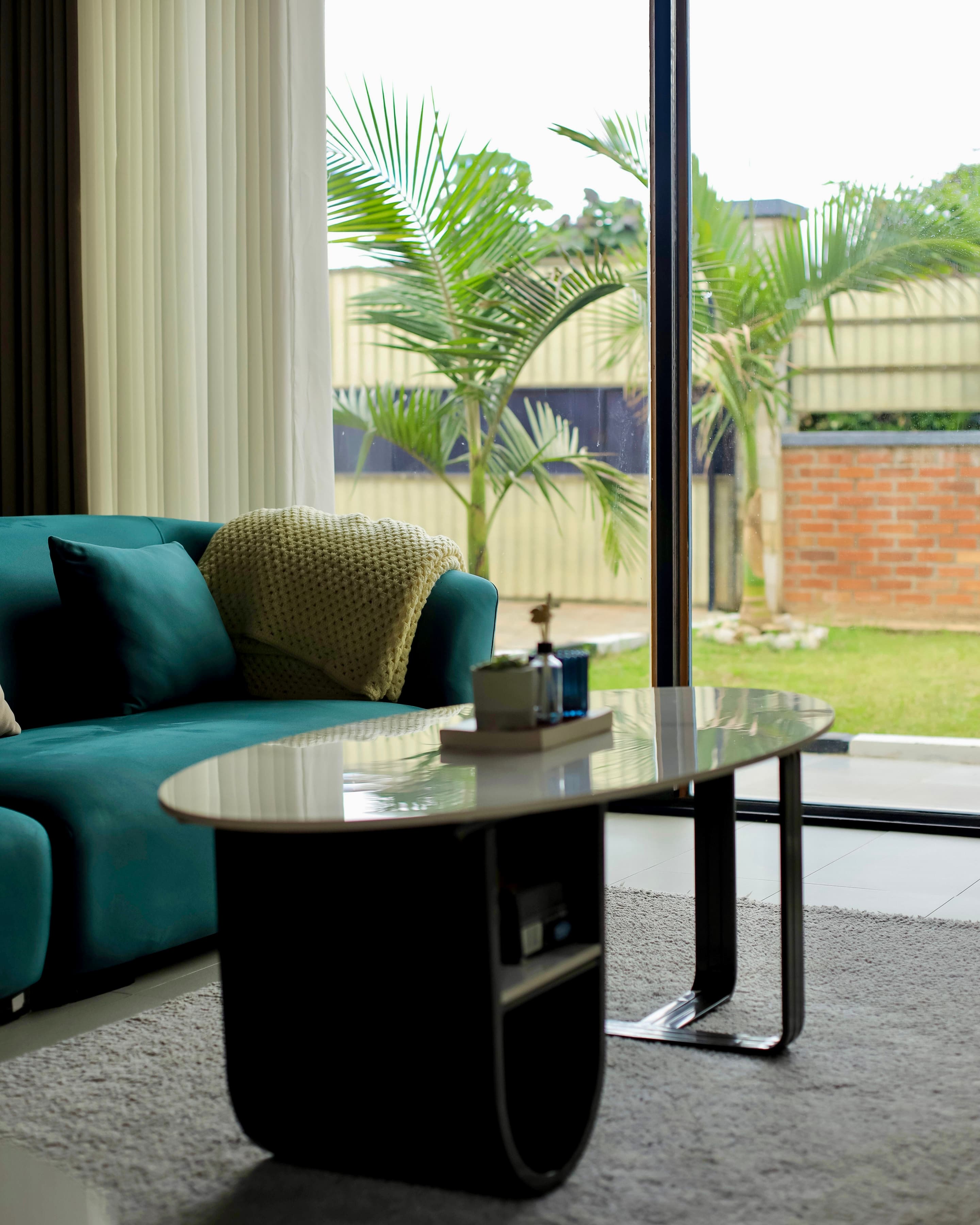 Velstays — the teal sofa and the garden beyond the glass