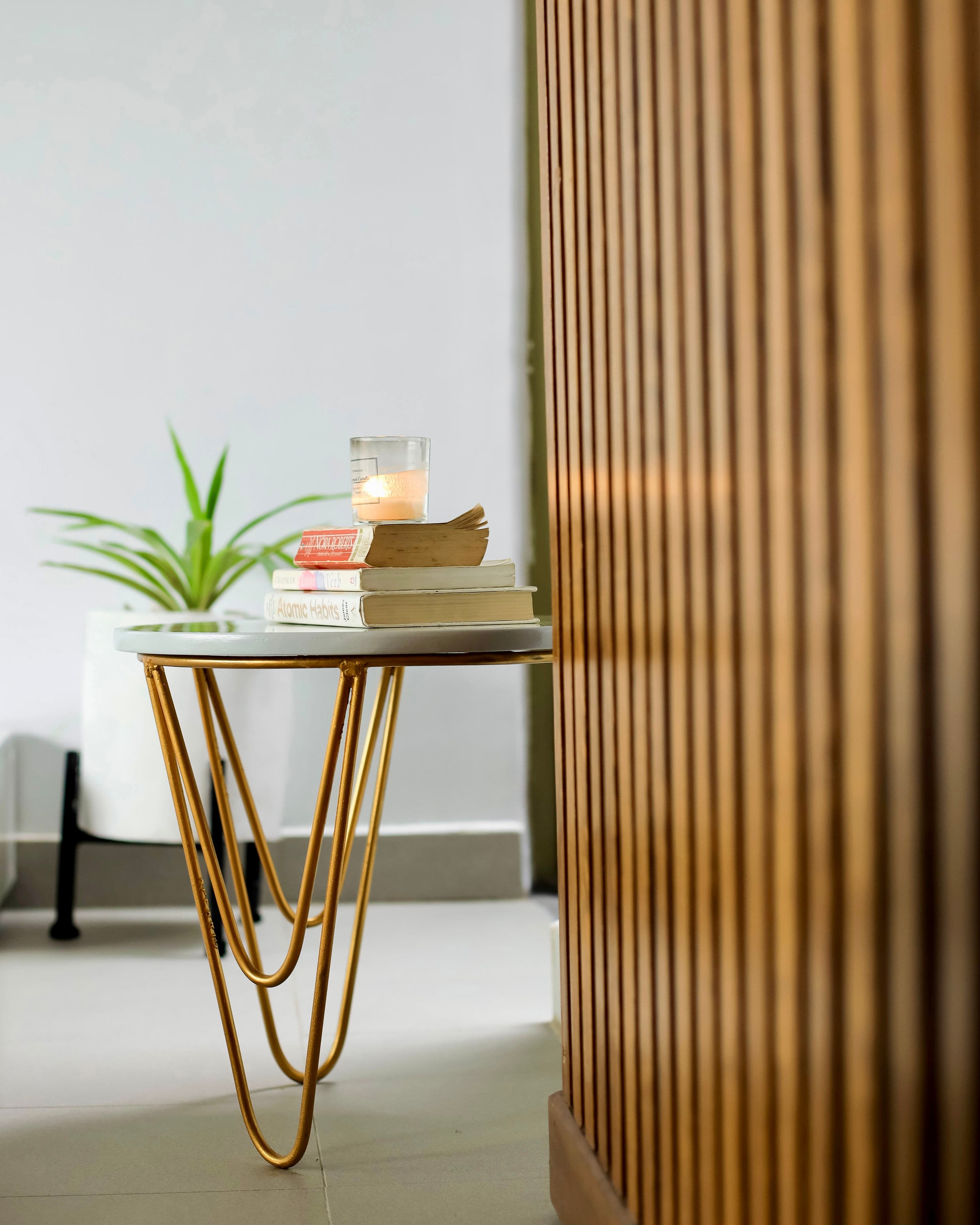 Velstays — books and a lit candle on the gold side table